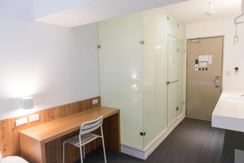 a room with a desk and a chair and a bathroom at Star Hostel Taipei Main Station in Taipei