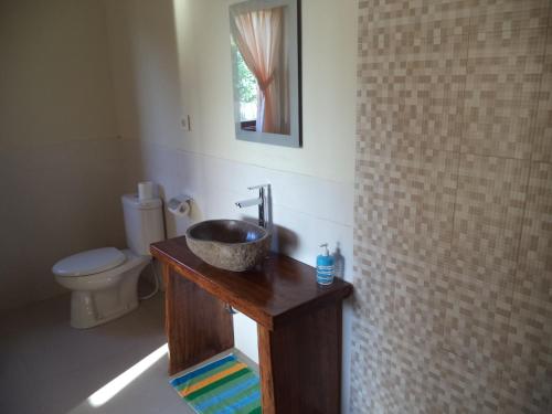 a bathroom with a sink and a toilet at Gula Juruh Beach Front in Amed