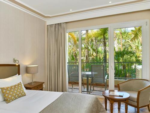 a hotel room with a bed and a balcony at Ria Park Hotel & Spa in Vale do Lobo