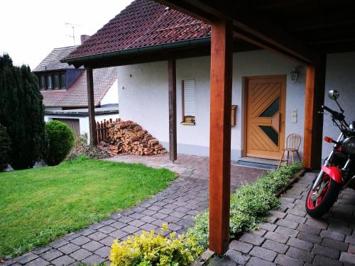 a motorcycle parked next to a house with a wooden door at Apartment mit Gartenblick in Forchheim