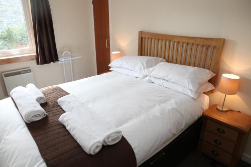 a bedroom with a bed with white sheets and pillows at Castleyards Apartment 2 in Kirkwall
