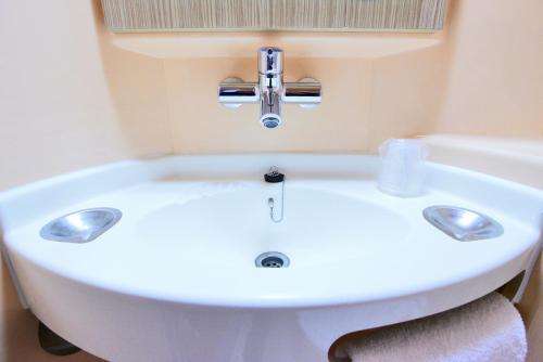 La salle de bains est pourvue d'un lavabo blanc et d'une baignoire. dans l'établissement Premiere Classe Conflans-Sainte-Honorine, à Conflans-Sainte-Honorine
