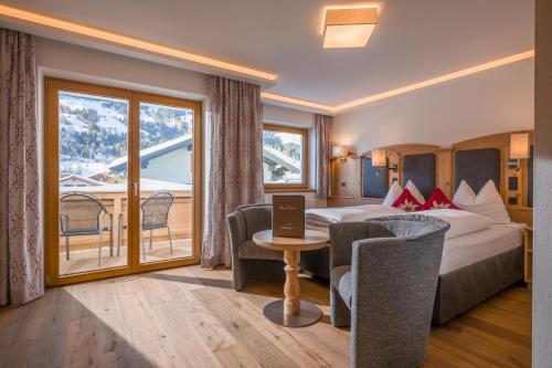 ein Hotelzimmer mit einem Bett und einem Tisch mit einem Laptop in der Unterkunft Hotel Bichlingerhof in Westendorf