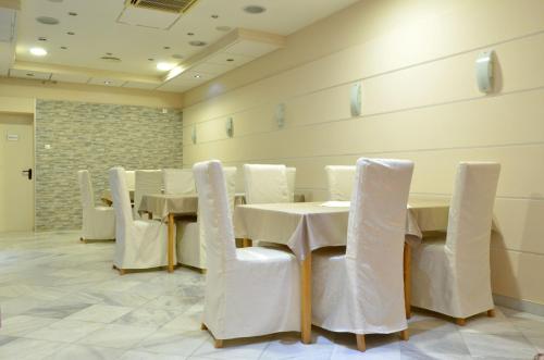 a dining room with a table and white chairs at Motel New Sanatron in Bosanski Novi