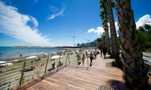a beach with people walking on a wooden boardwalk at Amalfitani Salerno Centro in Salerno