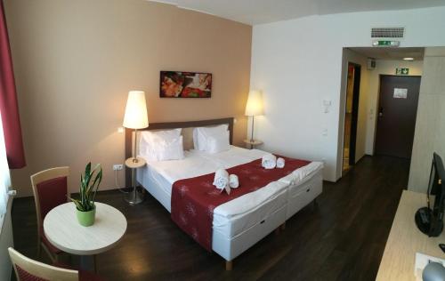 um quarto de hotel com uma cama grande e uma mesa em Hotel Opal Superior - Adults Only em Gyöngyös