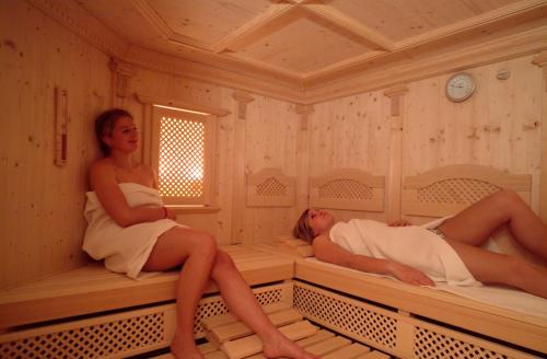 two women laying in beds in a room at Garni Haus Sonnleitn - Adults only in Fuschl am See