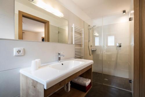 bagno con lavandino e doccia di Garni Grünau a San Martino
