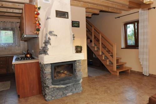 a living room with a fireplace and a staircase at Domki Oberwanka in Mszana Dolna