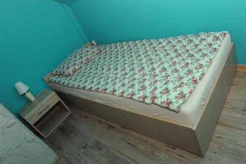 łóżko w pokoju z niebieską ścianą w obiekcie Domki Oberwanka w Mszanie Dolnej