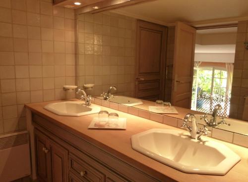 une salle de bain avec deux lavabos et un grand miroir dans l'établissement Le Bastidon Saint-Michel, à Sainte-Maxime