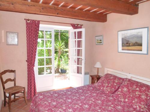 a bedroom with a bed and an open door at Le Bastidon Saint-Michel in Sainte-Maxime