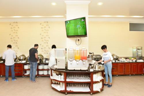 a group of people standing in a kitchen at Hotel Grand United - Ahlone Branch in Yangon