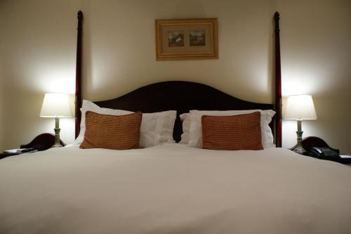 a bedroom with a large white bed with two lamps at Kievits Kroon Gauteng Wine Estate in Pretoria