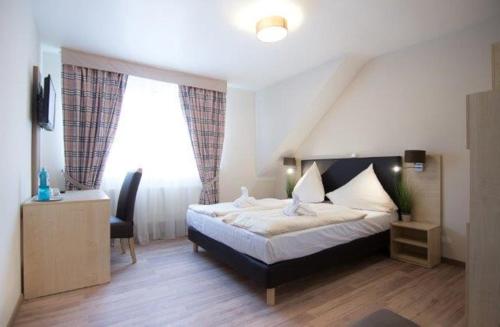 a bedroom with a bed and a chair and a window at Baum´s Rheinhotel in Boppard
