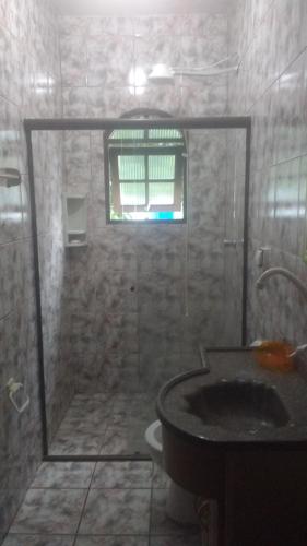 a bathroom with a shower and a sink at Pousada Brilho do Sol in Guarujá