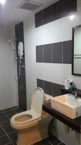 y baño con aseo y lavamanos. en Sayy Haa Inn, en Pantai Cenang
