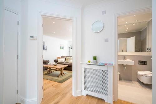a living room with a door open to a room with a couch at Sunny 2BR apt in the heart of Vauxhall, by subway in London