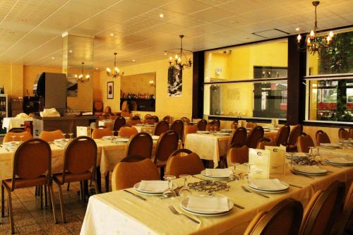 - une salle à manger avec des tables et des chaises dans l'établissement Hôtel des Rosiers, à Lourdes