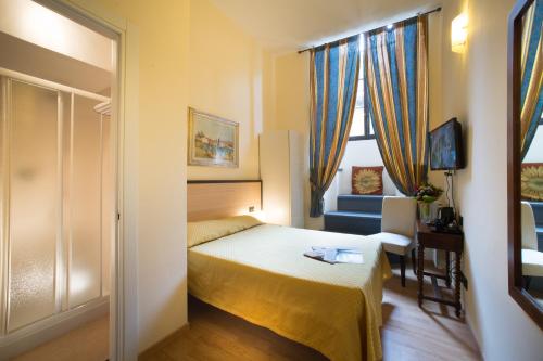 een slaapkamer met een bed, een stoel en een raam bij Locanda Orchidea in Florence