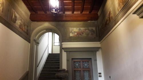a hallway with stairs and a ceiling and a door at Assaporarte in Florence
