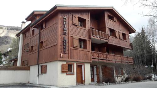 un gran edificio de madera con balcón en Vacancéole - Résidence Alpina Lodge, en Les Deux Alpes