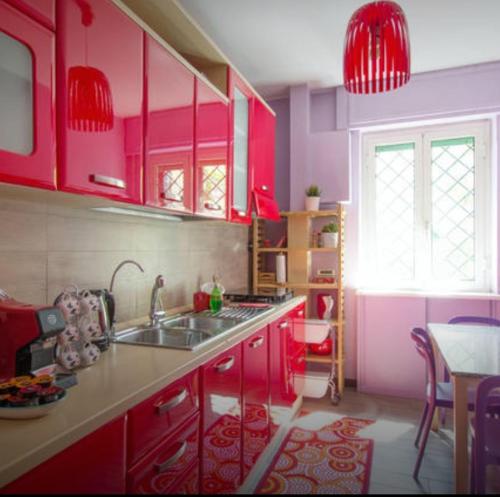 ローマにあるIl cerinoのキッチン(明るいピンクのキャビネット、テーブル付)