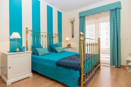 ポルティマンにあるAkisol Portimao Coralのベッドルーム1室(青い壁、青いシーツ付きのベッド1台付)
