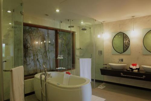 a bathroom with a tub and two sinks and a shower at Gulmohar Greens Golf & Country Club in Sānand