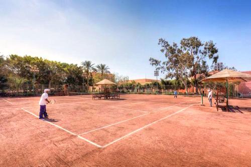three people playing tennis on a tennis court at Kefi Palmera Beach Resort El Sokhna - Family Only in Ain Sokhna