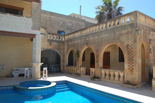 ein Haus mit einem Pool und einem Gebäude in der Unterkunft Mood Farmhouse Mythology in Għarb