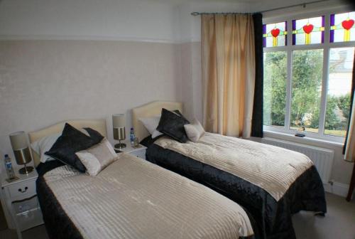 a bedroom with two beds and a window at Langdale House in St Austell