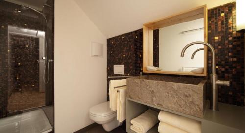 a bathroom with a sink and a toilet and a shower at Chalet INN in Innsbruck