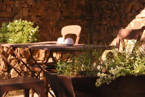 a table with a chair and a table and chairs at La Maison au Puits in Cordes-sur-Ciel
