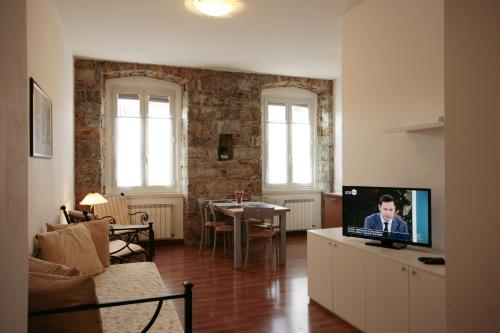 a living room with a couch and a tv on a cabinet at Residence Theresia- Tailor Made Stay in Trieste
