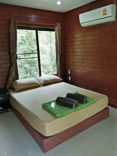 เตียงในห้องที่ Baanrai Saiyoknoi Resort