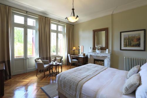 - une chambre avec un lit, un bureau et une cheminée dans l'établissement La Villa de Mazamet, à Mazamet