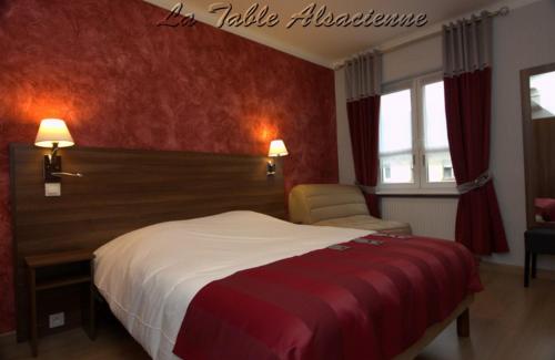a hotel room with a bed and a chair at La Table Alsacienne in Farébersviller