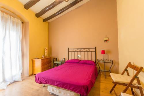 um quarto com uma cama com uma colcha rosa em INNOUTHOME Apartamento Andreu Llambrich em L'Ametlla de Mar