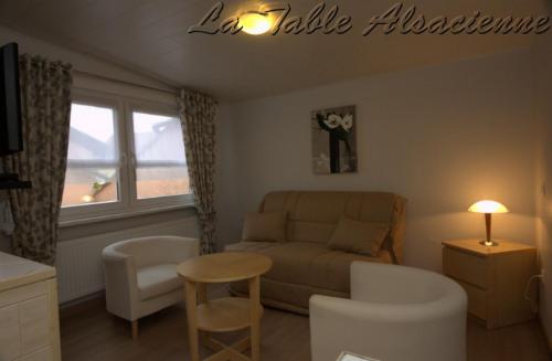 a living room with a couch and a table in it at La Table Alsacienne in Farébersviller