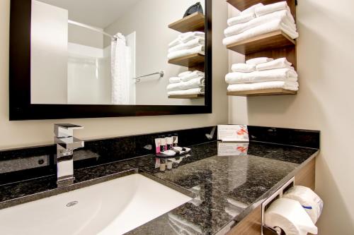 een badkamer met een wastafel, een spiegel en handdoeken bij Canalta Brooks in Brooks