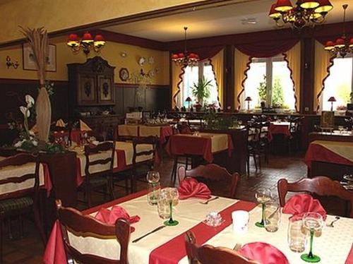 a restaurant with tables and chairs with red napkins on them at La Table Alsacienne in Farébersviller