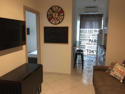 a living room with a clock on the wall at Murena Apartments & rooms in Rome