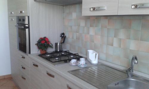 um balcão de cozinha com um lavatório e um fogão em Locazione Turistica alle Tre Civette em Noale