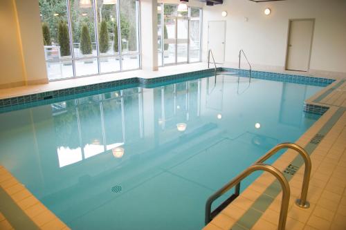 a swimming pool with blue water in a building at Harrison Beach Hotel in Harrison Hot Springs