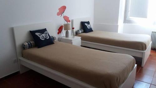 a bedroom with two beds and a window at Alojamento JCP in Bombarral