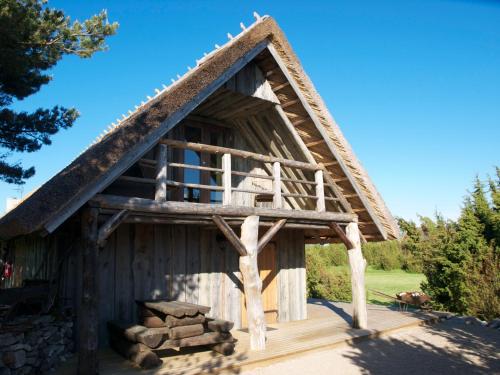a log cabin with a thatched roof at Aaduaida Holiday House in Suure-Rootsi