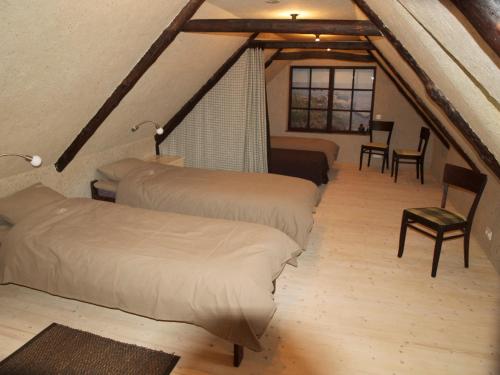 a attic room with three beds and a table and chairs at Aaduaida Holiday House in Suure-Rootsi