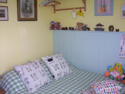 a childs bedroom with a bed and a shelf with stuffed animals at The Kings' House in Bramfield