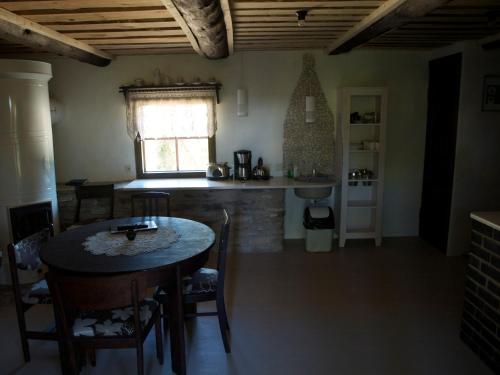 a kitchen and dining room with a table and a window at Aaduaida Holiday House in Suure-Rootsi